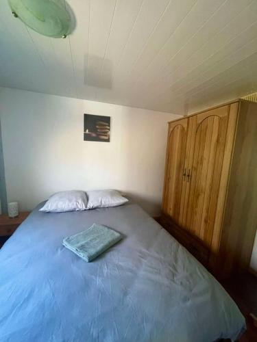 a bedroom with a blue bed with a wooden cabinet at Gite Raphael in Bourbourg