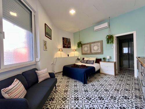 a living room with a couch and a bed at INT Studio totalmente equipado, 15' de BCN centro 8' playa in Sant Adria de Besos
