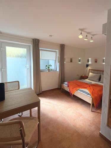 a bedroom with a bed and a table and a window at Gästehaus Stefan Koch in Rust