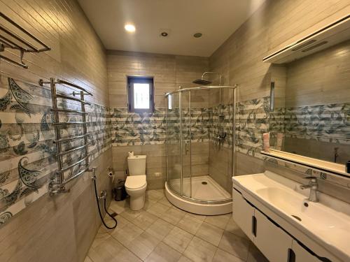a bathroom with a shower and a toilet and a sink at Villa lux in Qusar
