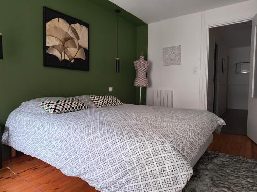 a bedroom with a bed with a green wall at Côté Jardin la belle époque in La Bourboule
