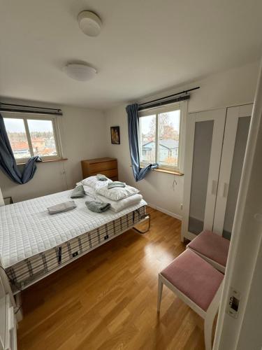 a bedroom with a bed and two windows at Lägenhet 2 sovrum med vardagsrum och kök i villa med gemensam ingång in Stockholm