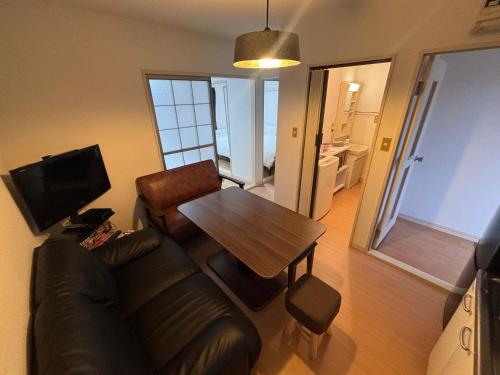 a living room with a couch and a table at ITO-STAY Apartment Hotel 阿蘇くまもと空港 #201 in Ozu