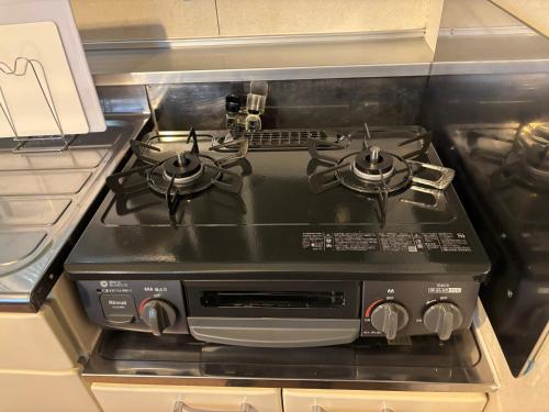 a stove top oven sitting in a kitchen at ITO-STAY Apartment Hotel 阿蘇くまもと空港 #201 in Ozu