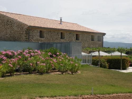 uma casa com flores cor-de-rosa em frente a um quintal em Luxury g te in a renovated farmhouse em Rieux-Minervois