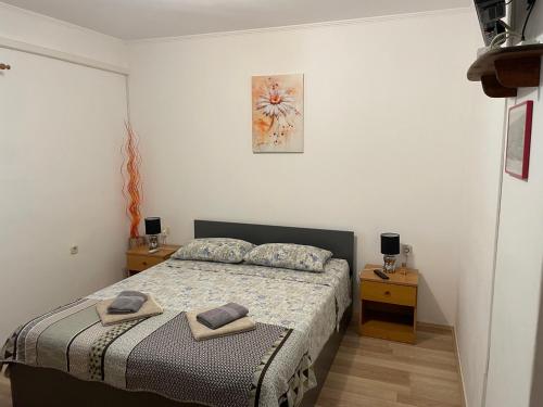 a bedroom with a bed with two night stands and two tables at Apartmani Luiza in Cres