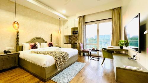 a bedroom with a bed and a desk and a window at BluO Medicity - Boutique Hotel Gurgaon in Gurgaon