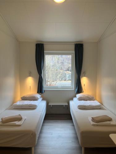 two beds in a room with a window at Trolltunga Camping in Odda