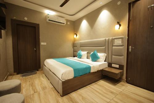 a bedroom with a large bed with blue pillows at Hotel Mantra Inn in Haridwār