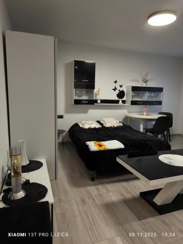 a bedroom with a black bed and a table at Atpūta pie Gora in Rēzekne