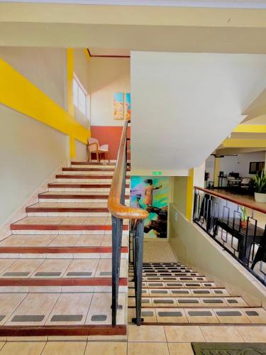 a staircase in a room with yellow and white walls at Hotel Miami CR in Puerto Limón