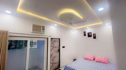 a bedroom with a bed with pink pillows on it at SOALTEE Near Lucknow Airport in Lucknow