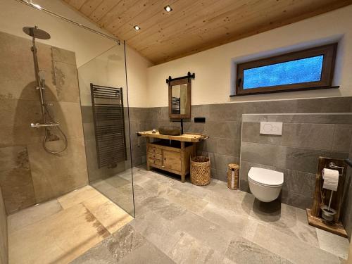a bathroom with a shower and a toilet and a sink at Ferienhaus Steinschlössl in Mühldorf