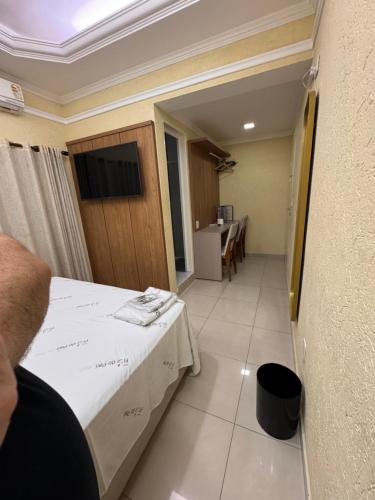a room with a bed and a table and a kitchen at Hotel Flor do Pari in São Paulo