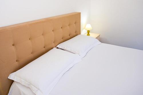 a bedroom with a white bed with a headboard at Sunny Breeze Hotel in Vlorë