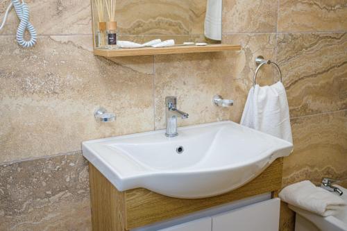 a bathroom with a white sink and a mirror at Sunny Breeze Hotel in Vlorë