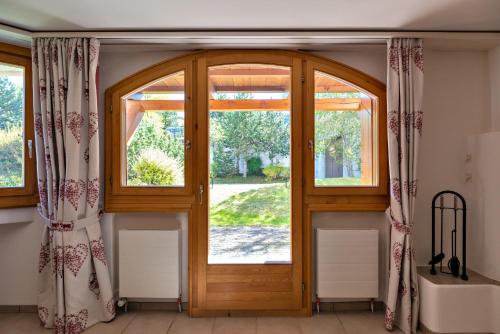 an open wooden door with curtains in a room at Chesa Foulla Rosa - Celerina in Celerina