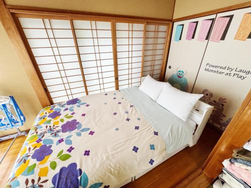 a bedroom with a bed with flowers on it at Yufu Inn in Yufu