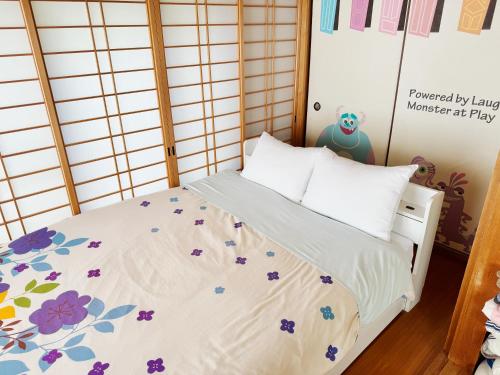 a bedroom with a bed with flowers on it at Yufu Inn in Yufu