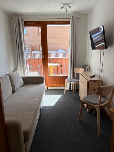 a living room with a couch and a television at Studio Tignes Val Claret in Tignes
