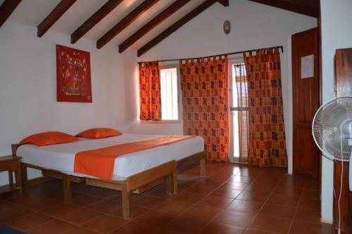 a bedroom with a bed and a fan and windows at Résidence KEUR FLEURIE in Rufisque