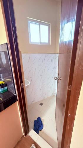 a bathroom with a shower with a glass door at Dexter John's Guesthouse in Agus
