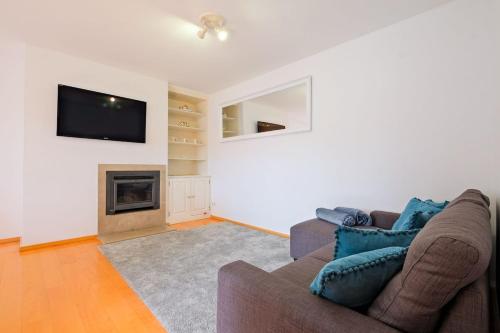 a living room with a couch and a fireplace at Bright & Modern Duplex with Terrace Telheiras in Lisbon