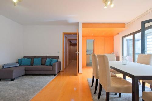 a living room with a table and a couch at Bright & Modern Duplex with Terrace Telheiras in Lisbon