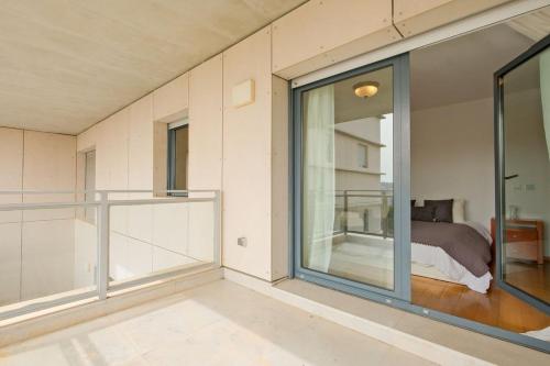 a bedroom with sliding glass doors and a bed at Bright & Modern Duplex with Terrace Telheiras in Lisbon