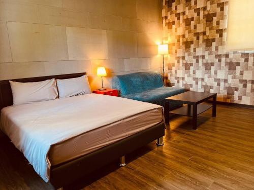 a bedroom with a bed and a chair and a table at Pet Truelove in Hengchun South Gate