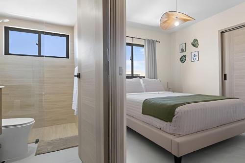a white bedroom with a bed and a bathroom at Atabey II – Epic Residence, Bávaro in Punta Cana