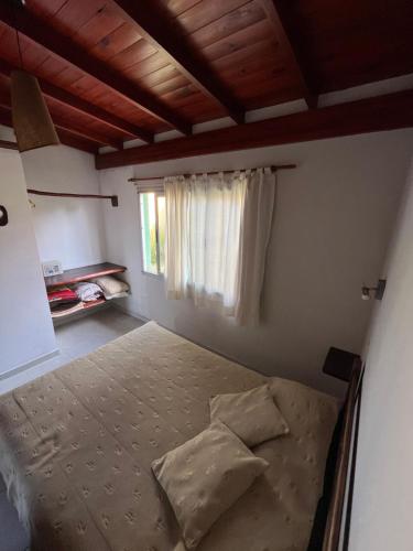 a bedroom with a bed and a window at Ayres de Cobo in Mar de Cobo