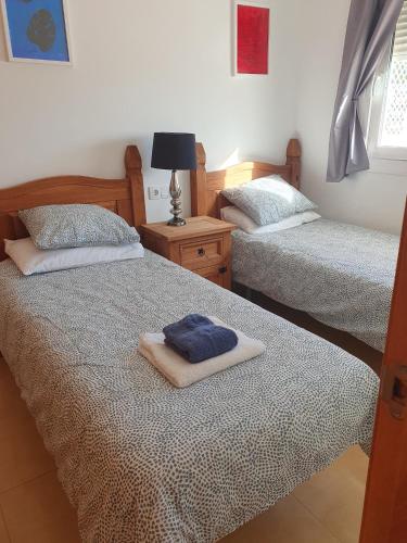 a bedroom with two beds with towels on them at Spacious and peaceful apartment Jardin 2 in Alhama de Murcia
