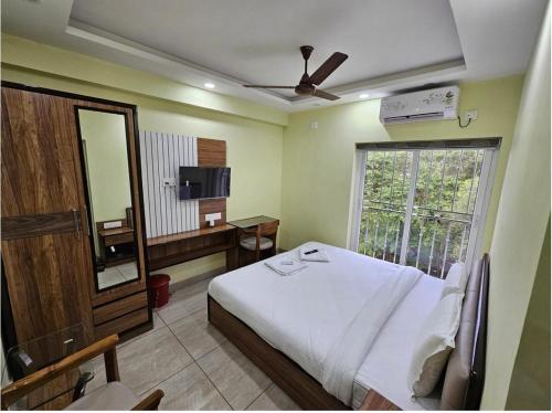a bedroom with a bed and a mirror and a window at V3 Inn Private Limited in kolkata