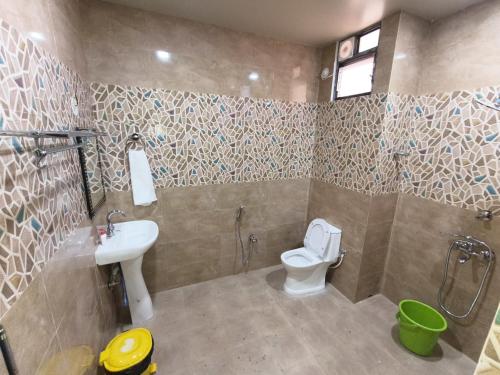 a bathroom with a toilet and a sink and a shower at Ankush Resort in Vishnupur