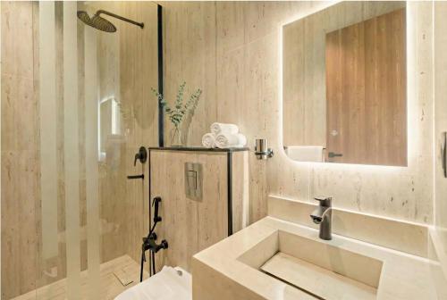 a white bathroom with a sink and a mirror at LIV by Yamama - KAFD in Riyadh