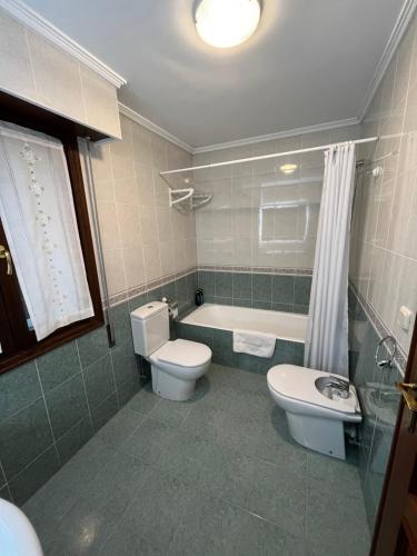 a bathroom with a toilet and a tub and a sink at Blaxenea in Aia