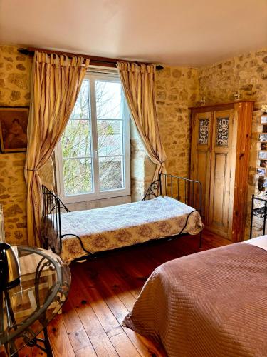 a bedroom with two beds and a window at Aux Caprices des Dieux in Marnes
