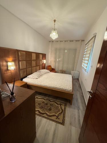 a bedroom with a large bed and a chandelier at Dar Zina in Mteurch