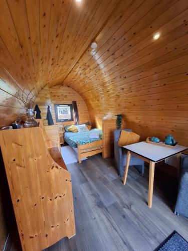 ein großes Holzzimmer mit einem Bett und einem Tisch in der Unterkunft Swifterlodge in Kerkenveld