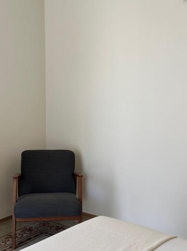 a chair sitting in a room next to a bed at F Home in Noto