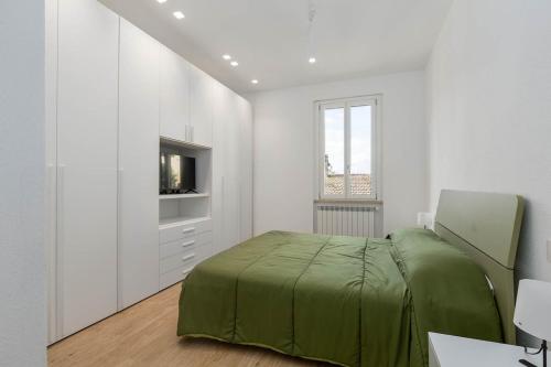 a white bedroom with a bed and a tv at House Tuscany in Poggibonsi