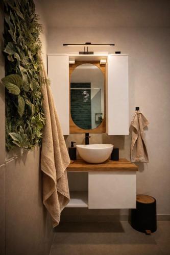a bathroom with a sink and a mirror at Stylish Townhouse- central & quiet in Prishtinë