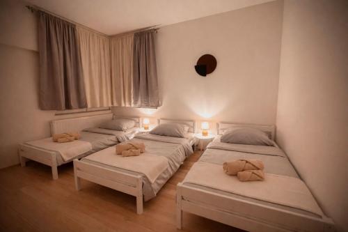 a group of four beds in a room at Stylish Townhouse- central & quiet in Prishtinë