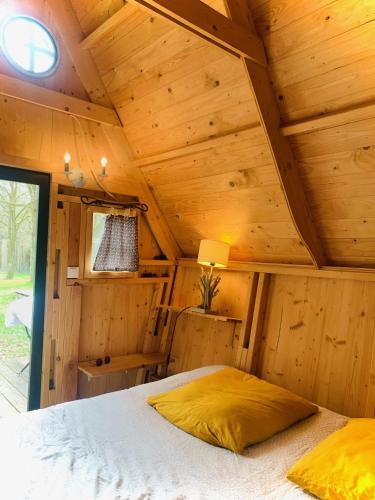a bedroom with a bed in a wooden cabin at camping de brocéliande in Néant-sur-Yvel