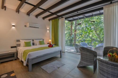 a bedroom with a bed and a balcony at Leopard Eye Resort in Kitulgala