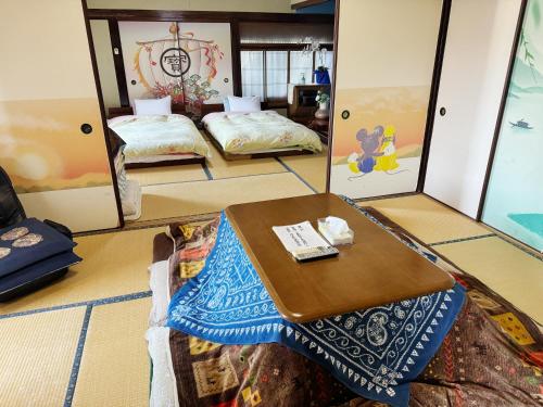 a room with two beds and a table in it at 天ゆふ(Ten Yufu) in Yufu