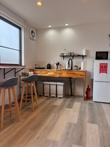 a kitchen with a wooden counter and a white refrigerator at 細島 Base Clutch in Hyuga