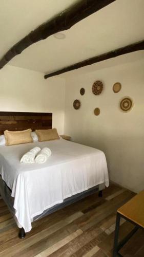 a bedroom with a white bed with two white towels at Hot Chipilin El Paredon in Sipacate