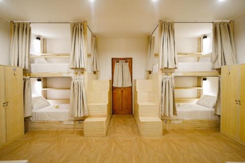 a room with three bunk beds and a door at SunDay Hostel in Siquijor